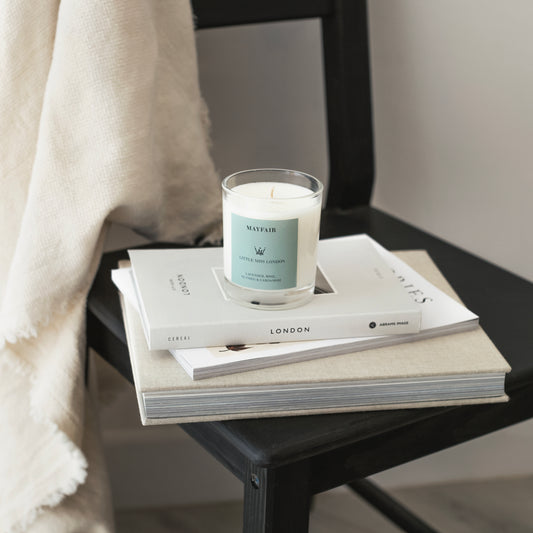 Little Miss Mayfair Candle displayed on white books