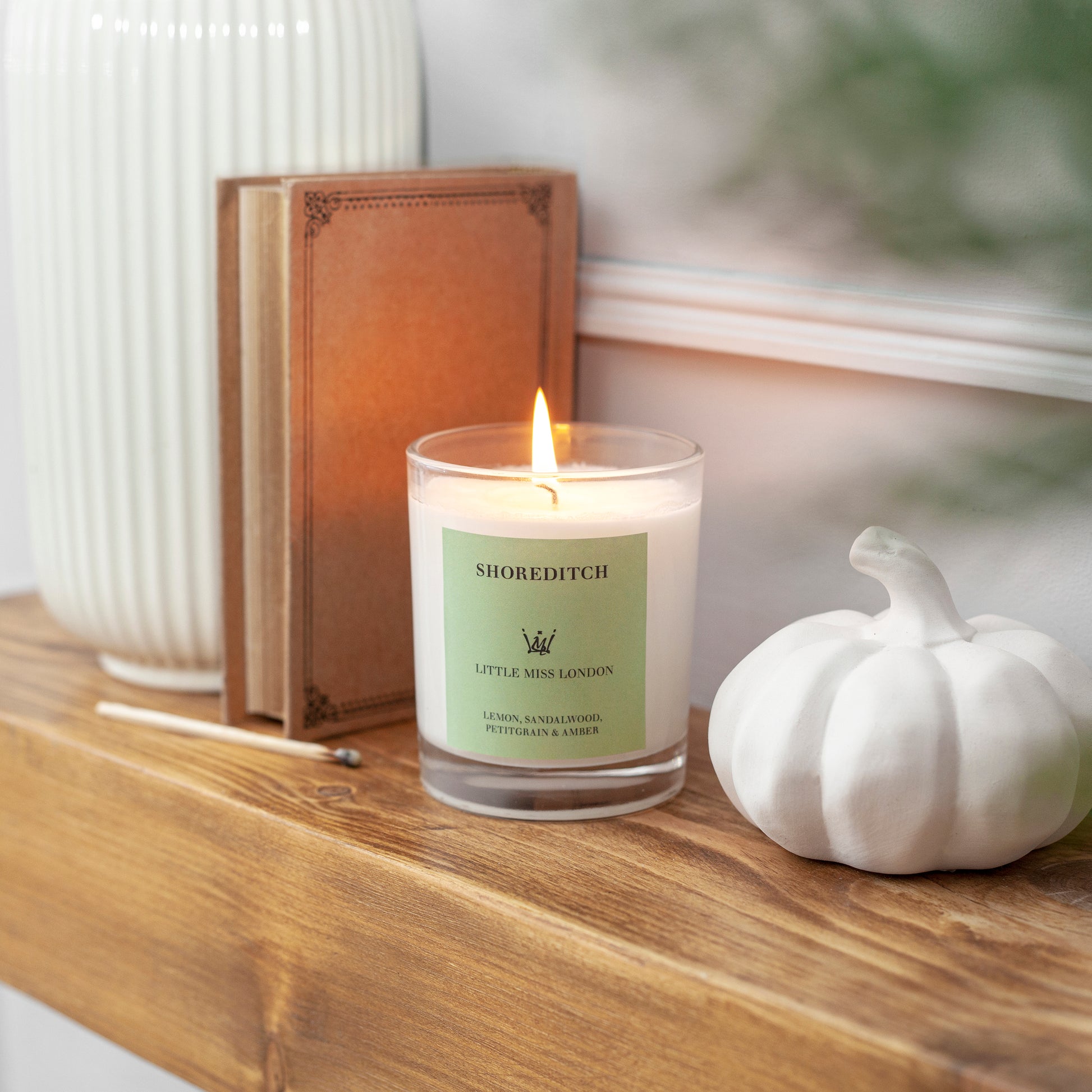 Little Miss Shoreditch Candle, lit on a wooden sideboard