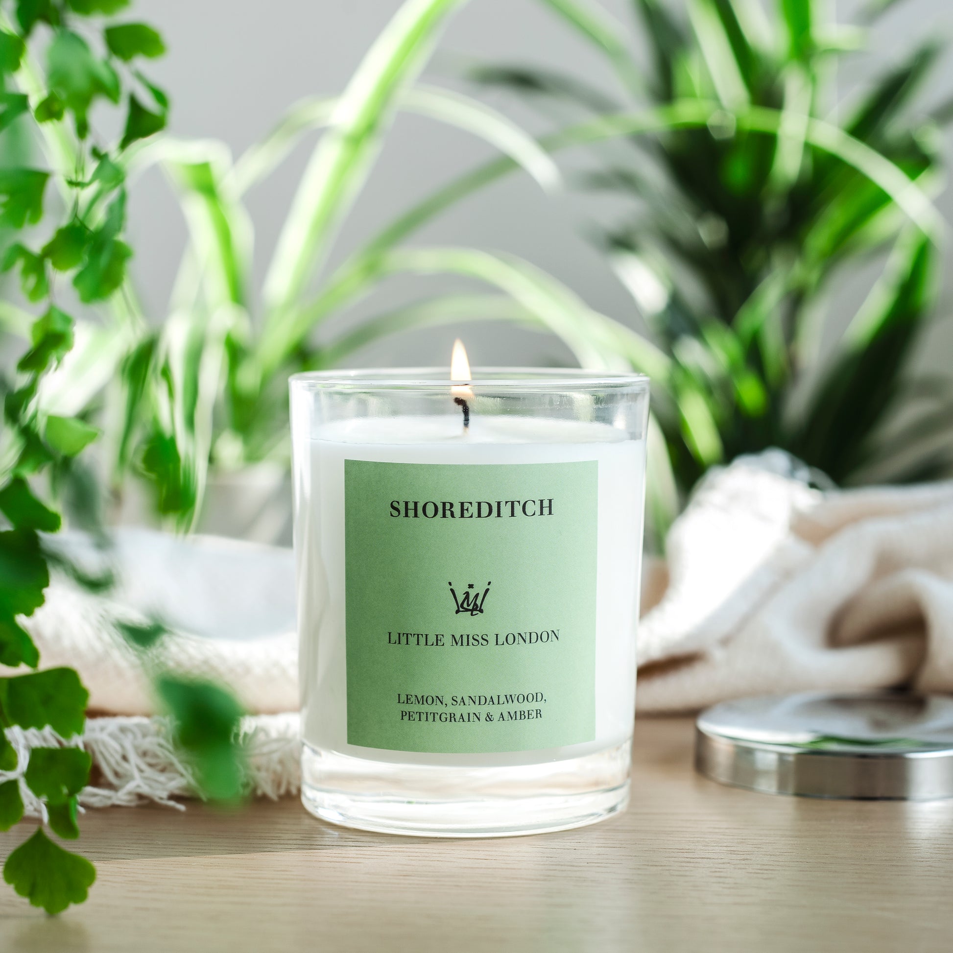 Little Miss Shoreditch Candle, lit on a table