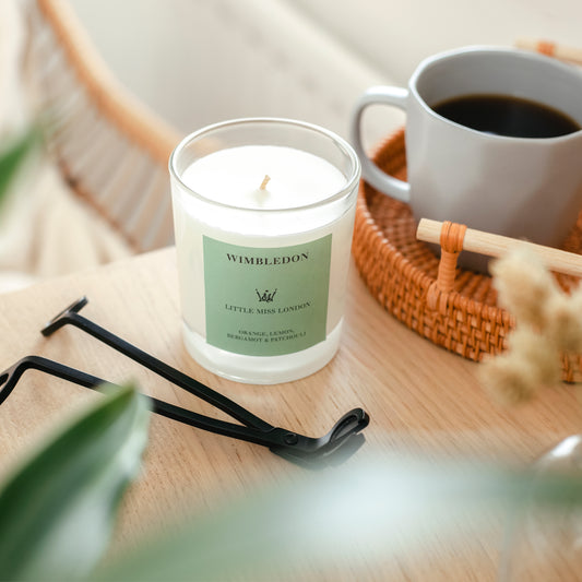 Little Miss Wimbledon Candle next to a coffee